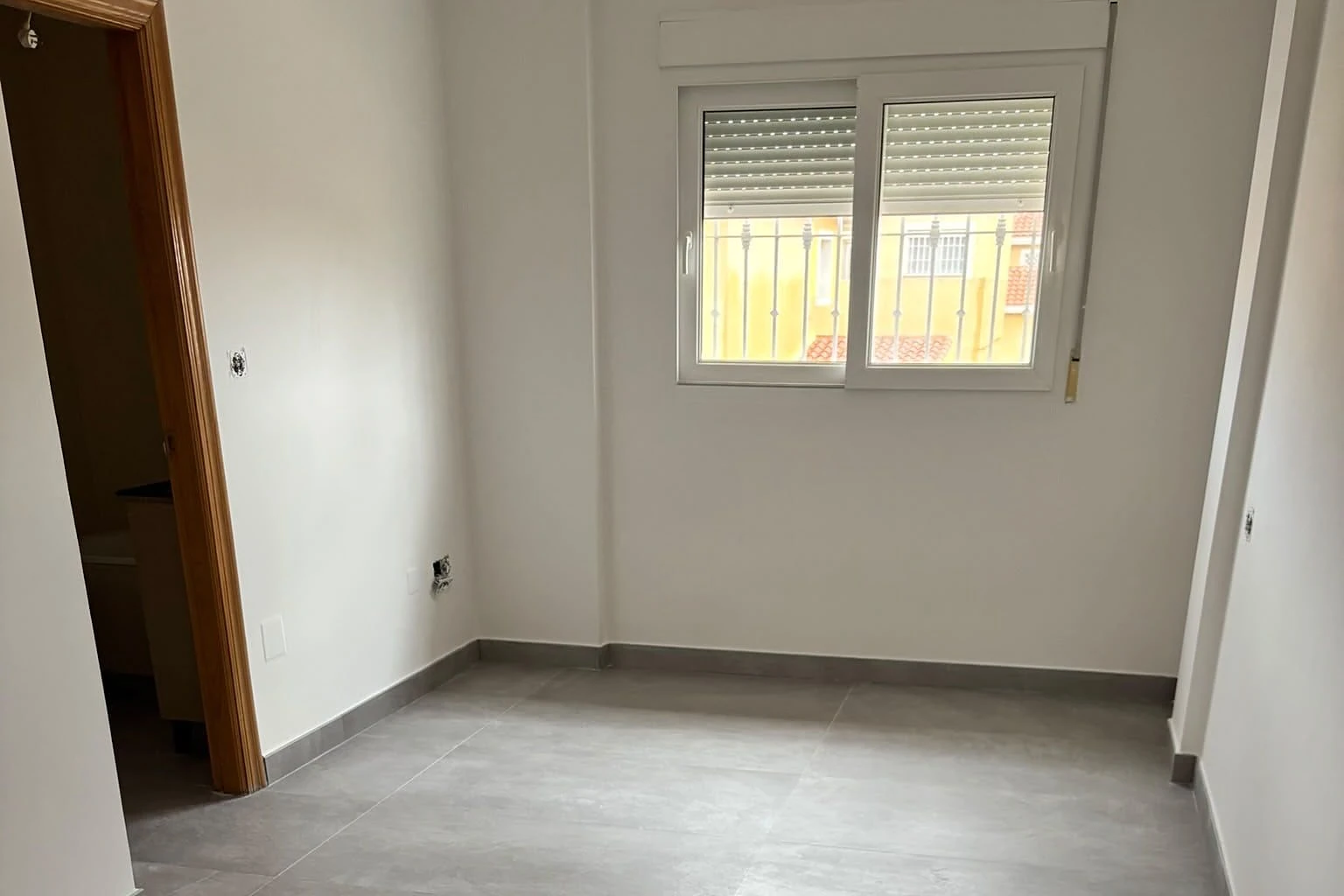Dormitorio con suelo porcelánico gris de gran formato